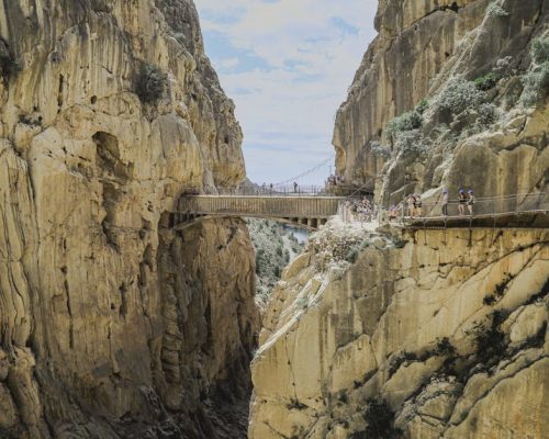 Explore the breathtaking Caminito del Rey footbridge nestled between rugged cliffs in Spain's mountains.